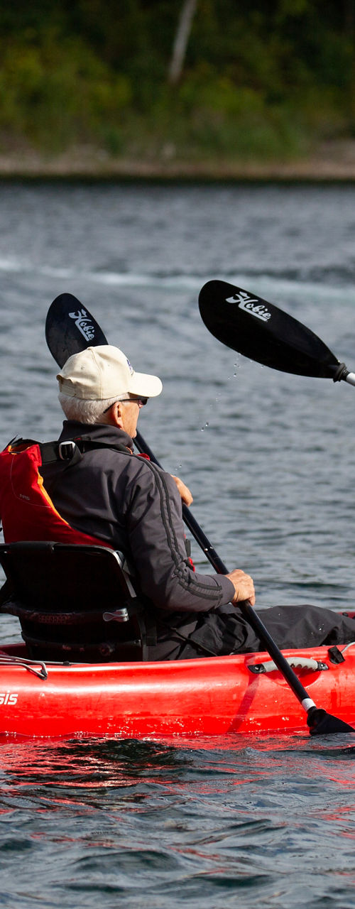 Two adults kayaking on a calm lake