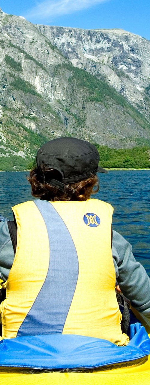 Kayaker paddling through scenic mountain fjord
