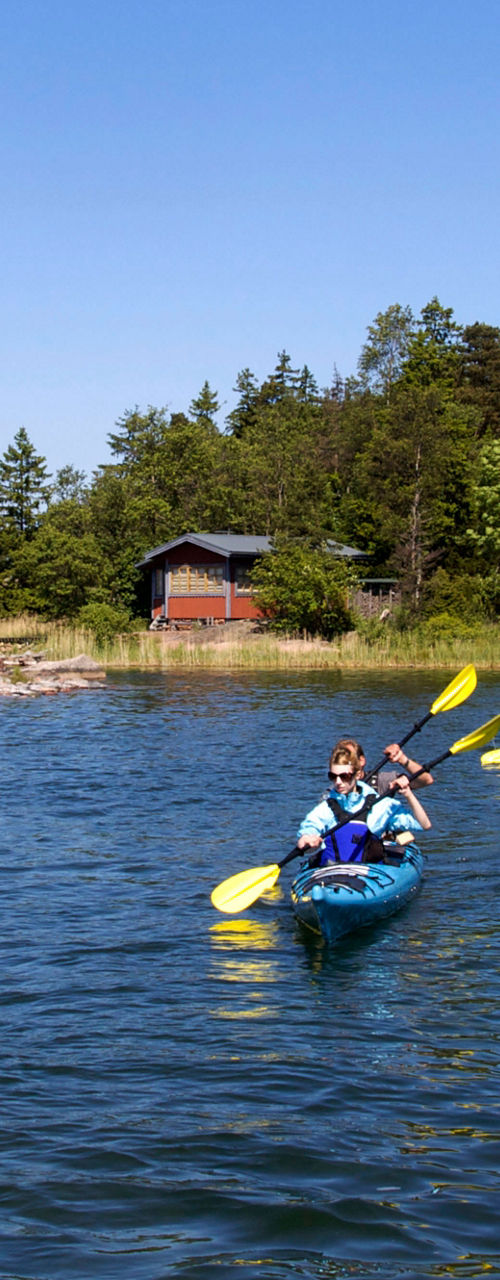 Group kayaking near lakeside cabins