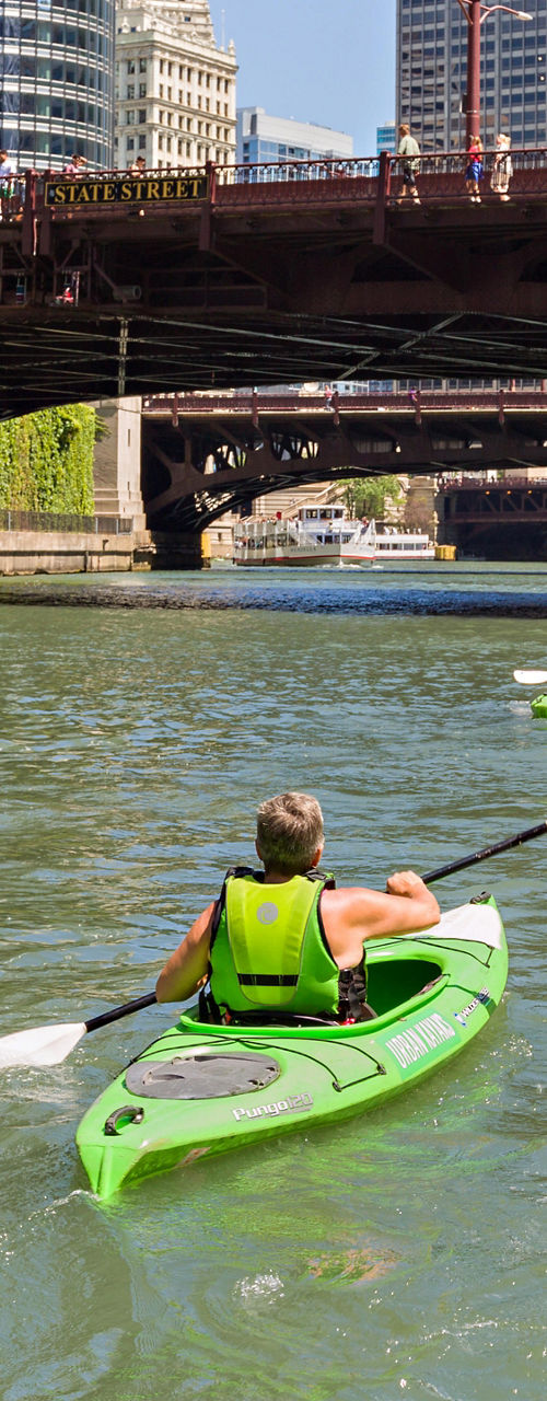 Group kayaking under Chicago city bridge