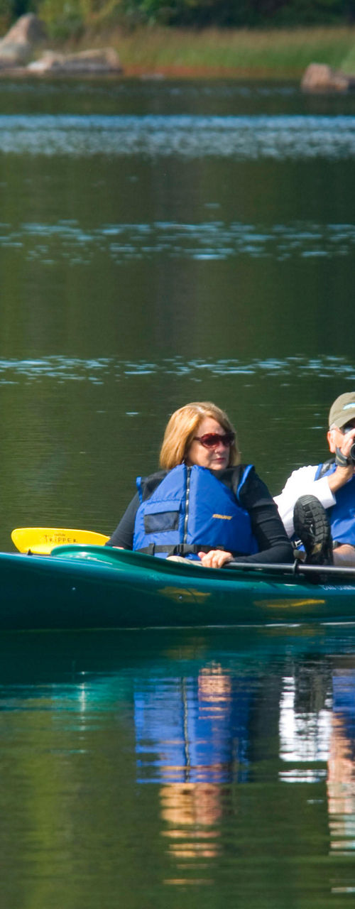 Couple kayaking on calm lake waters