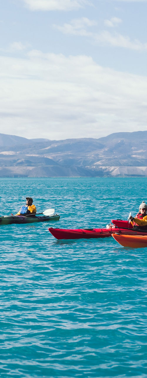Group kayaking on scenic blue waters