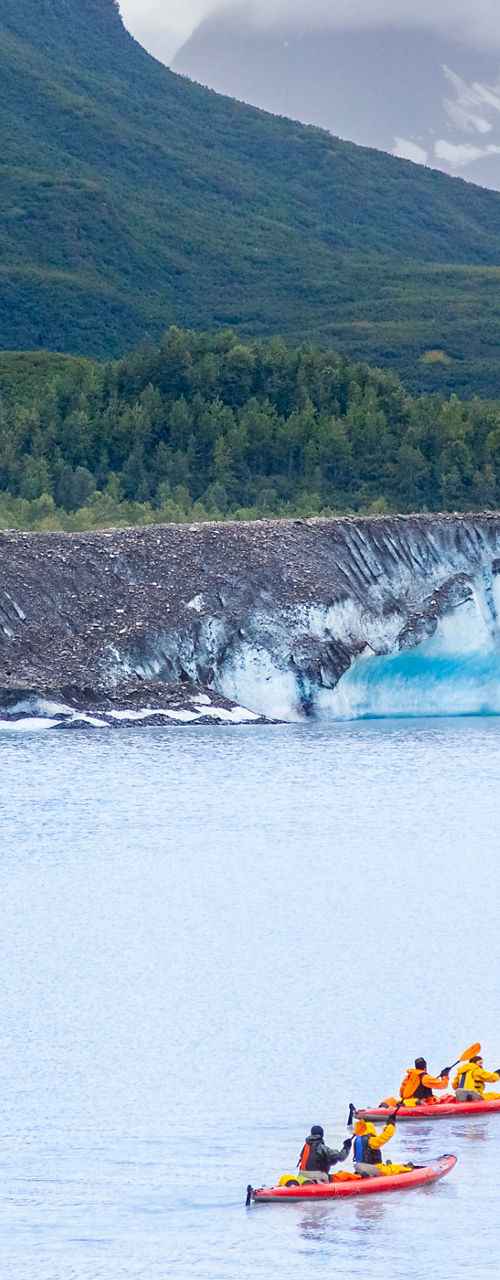 Kayakers near glacier in scenic landscape