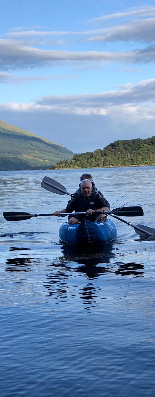 Solo kayaker paddling on tranquil mountain lake