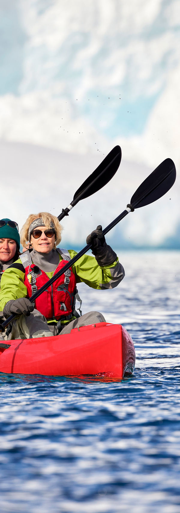 Kayakers in icy waters near glacier