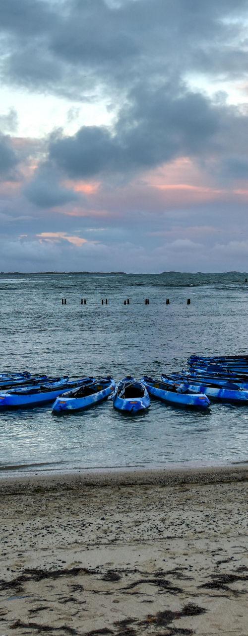 Kayaks on a tropical beach at sunset
