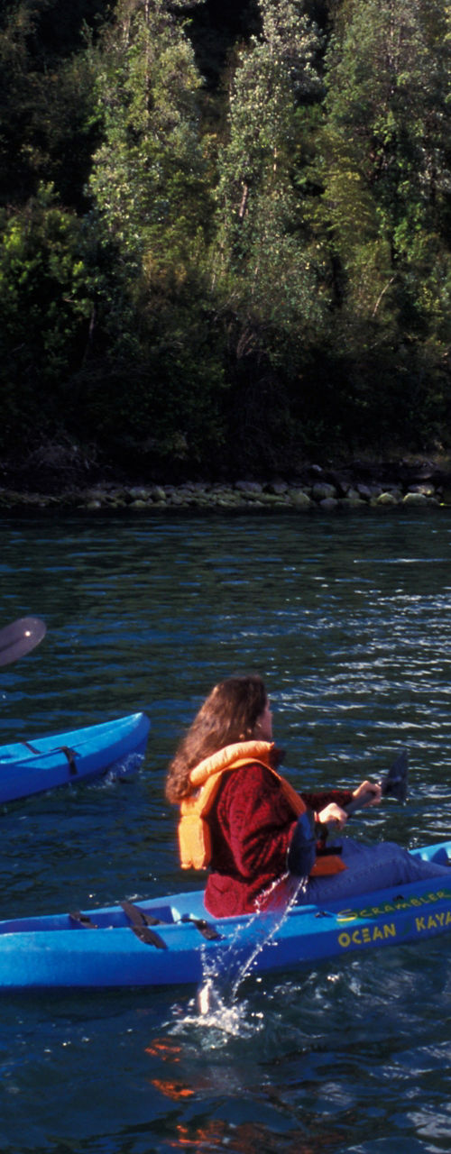 Two kayakers paddling on scenic lake