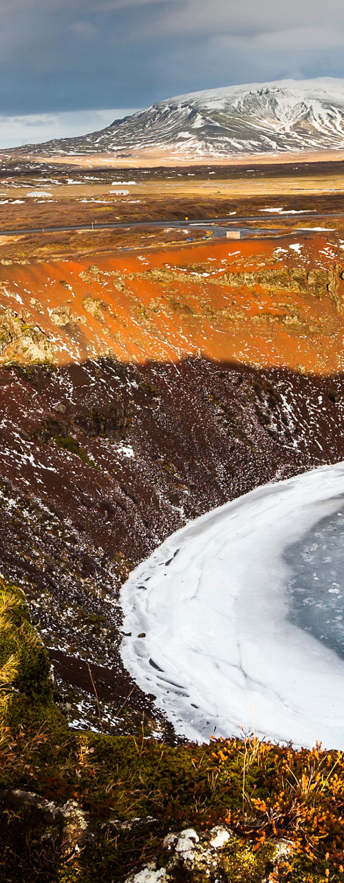 Frozen crater lake in rugged landscape