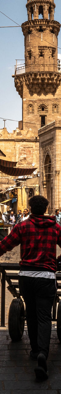 Man pushing cart through historic Middle Eastern street