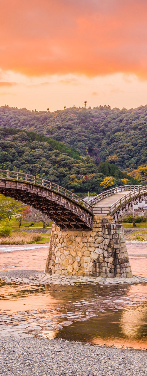 Kintai Bridge at sunset with scenic hills