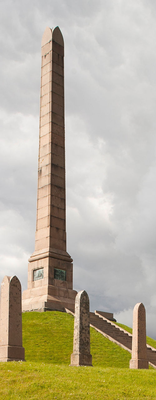 Tall stone obelisk on grassy hill