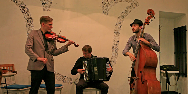 Trio performing with violin, accordion, bass