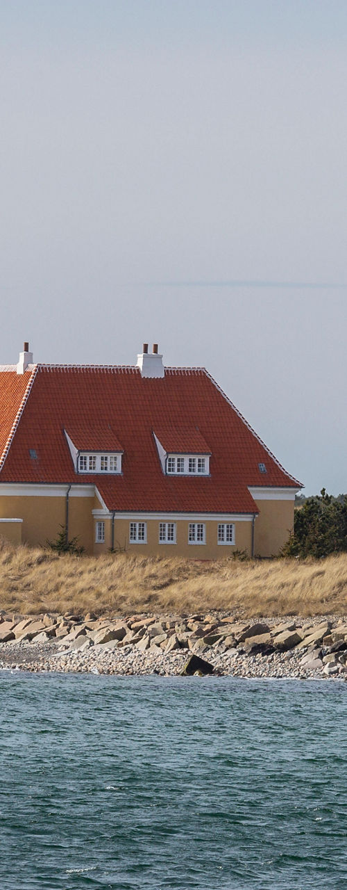 Coastal house with red roof and flag