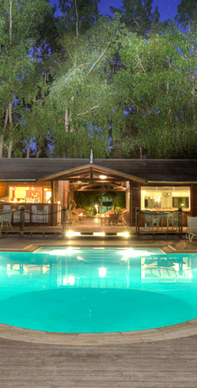 Luxury lodge with illuminated pool at night