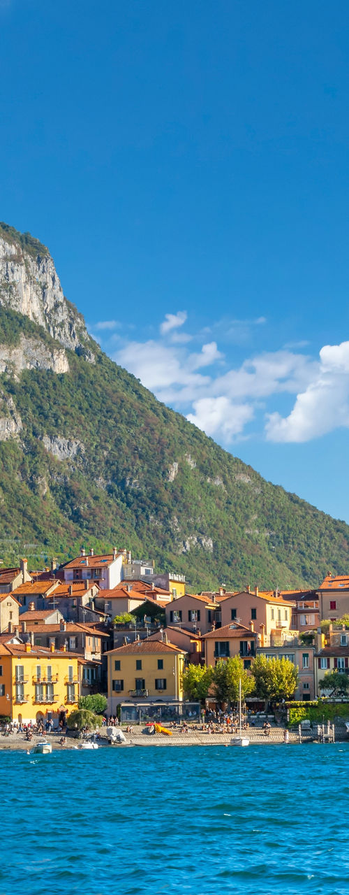 Colorful lakeside village beneath mountain cliffs