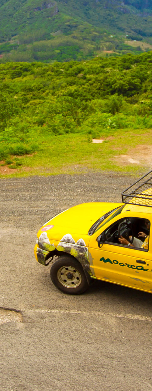 Yellow safari truck in tropical mountain landscape