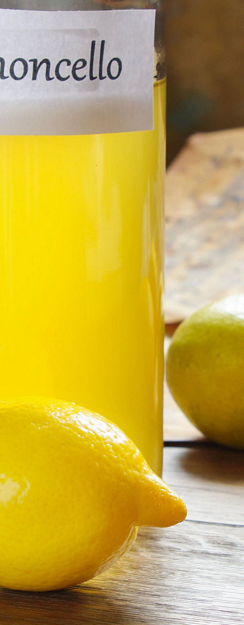 Limoncello bottle with fresh lemons
