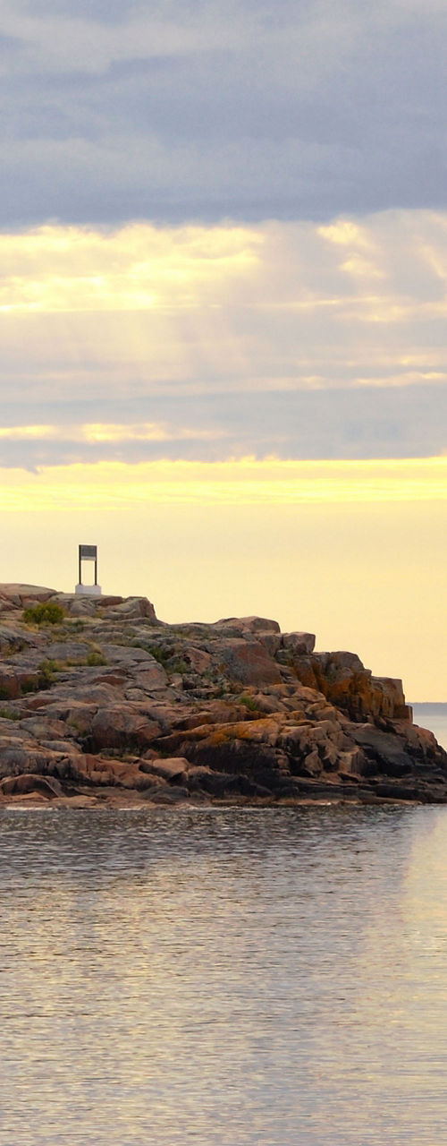Scenic lighthouse on rocky coastline at sunset