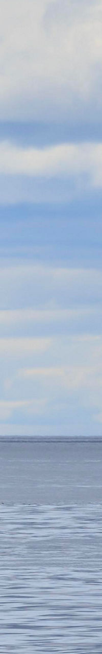 Red and white lighthouse on calm sea