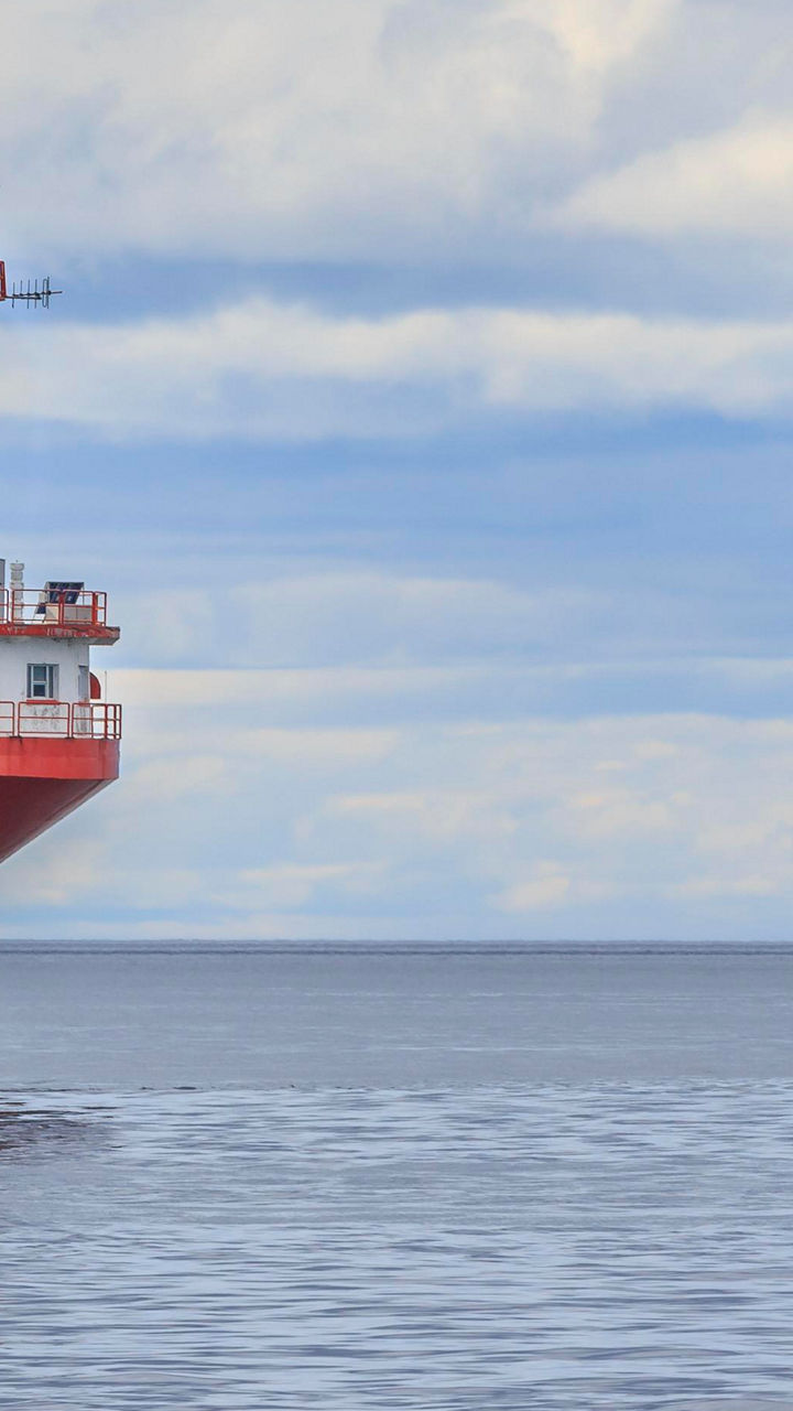 Red and white lighthouse on calm sea