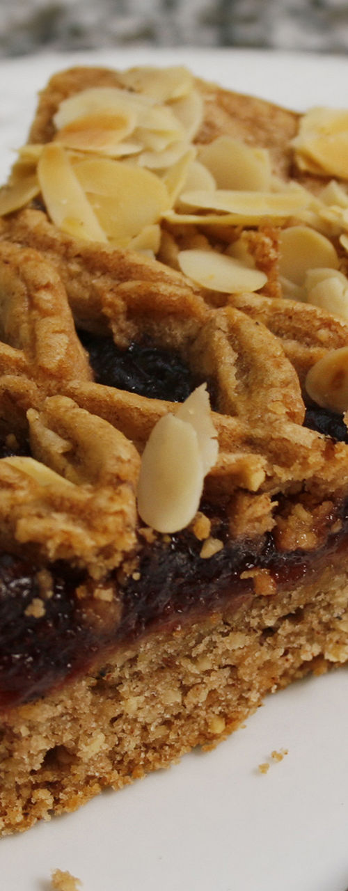 Slice of almond-topped fruit tart on plate