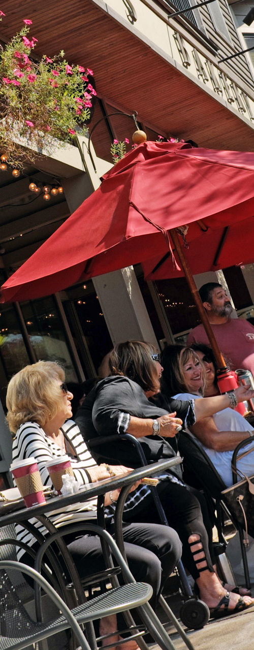 Outdoor café with red umbrellas and patrons