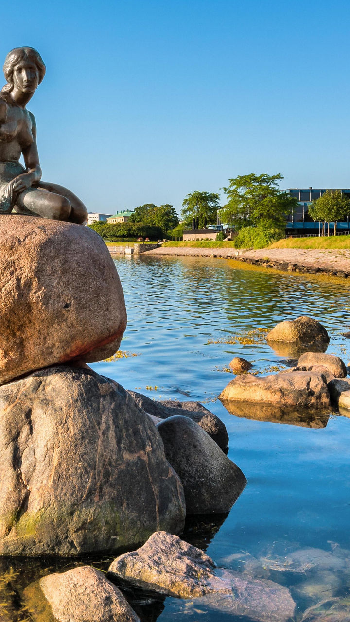 Little Mermaid statue by waterfront rocks