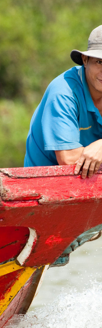 Man on colorful wooden boat in river