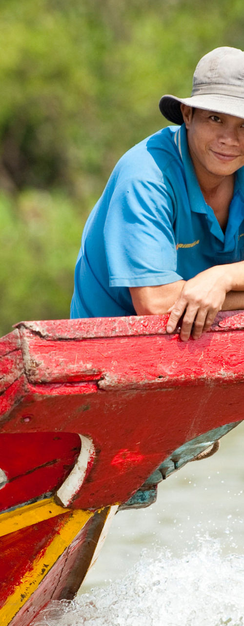 Man on colorful wooden boat in river