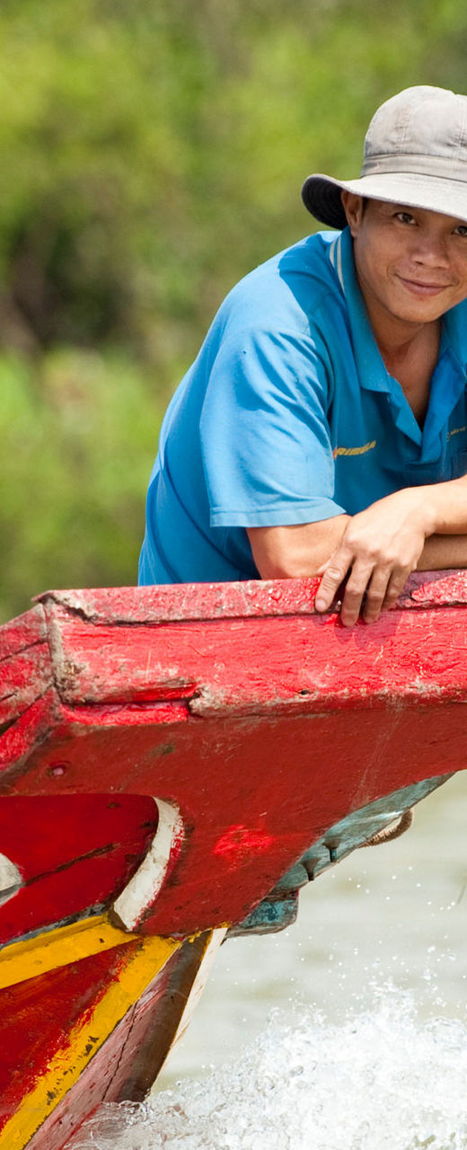 Man on colorful wooden boat in river