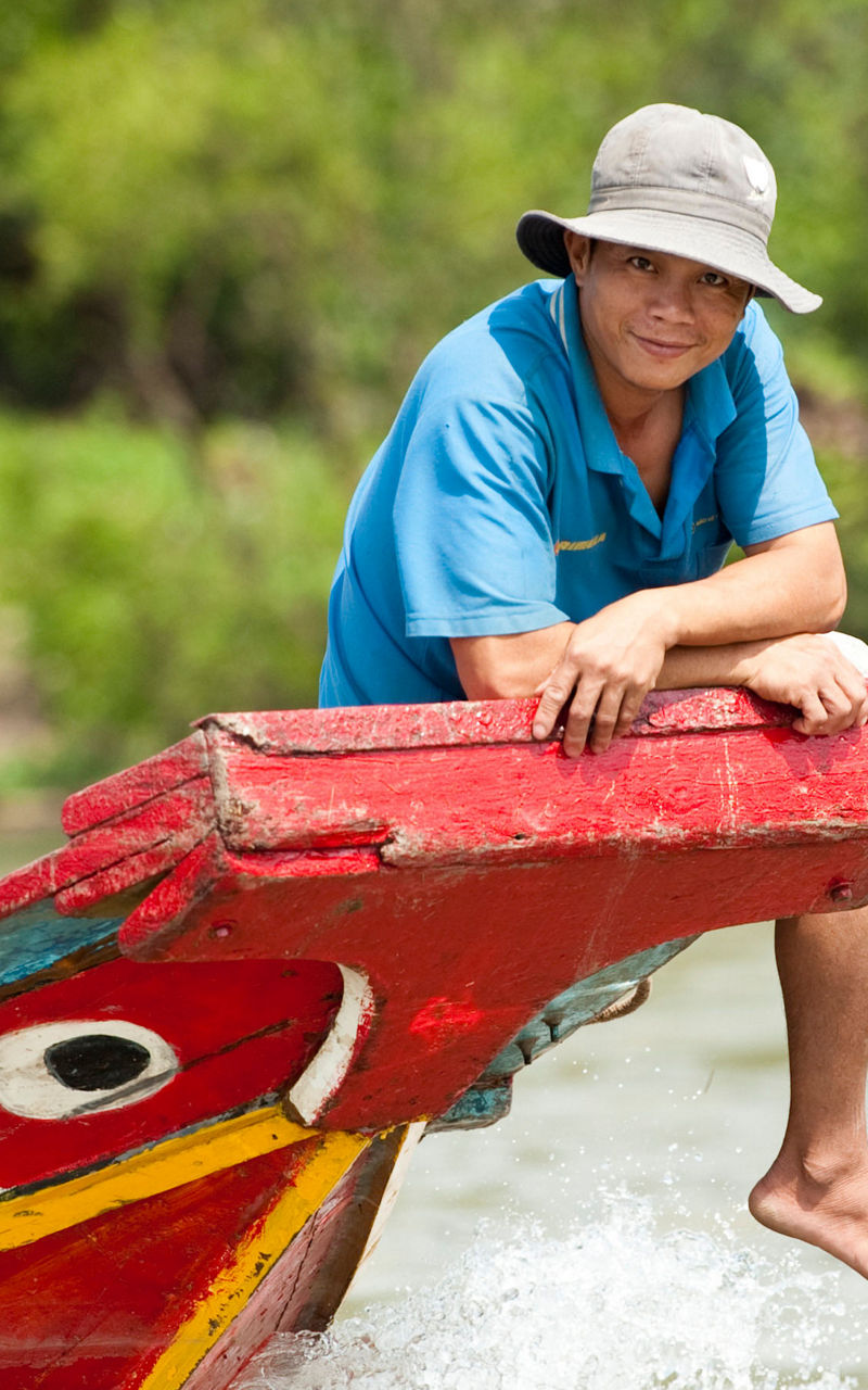 Man on colorful wooden boat in river