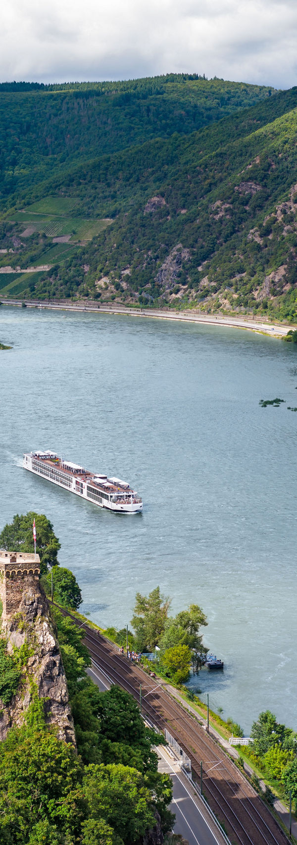 Historic riverside castle with scenic mountain backdrop