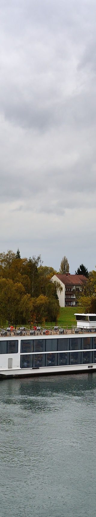 Modern river cruise ship docked near European village