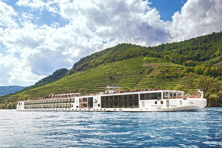 Luxury river cruise ship in scenic landscape