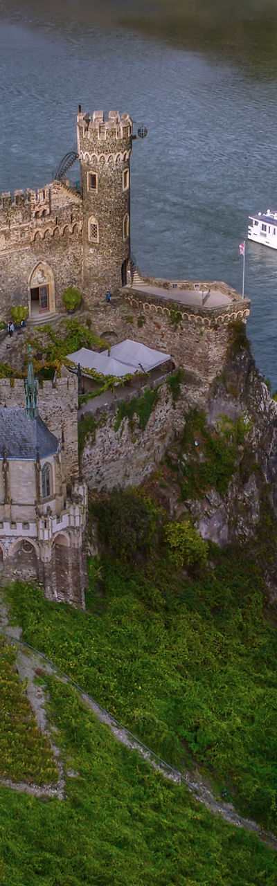 Historic riverside castle with passing cruise ship