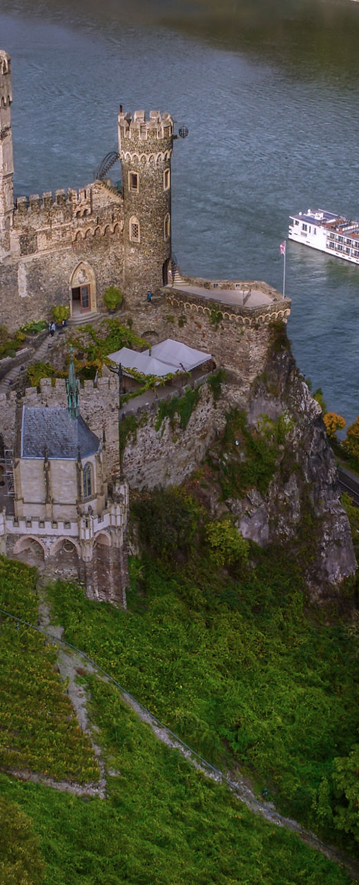 Historic riverside castle with passing cruise ship