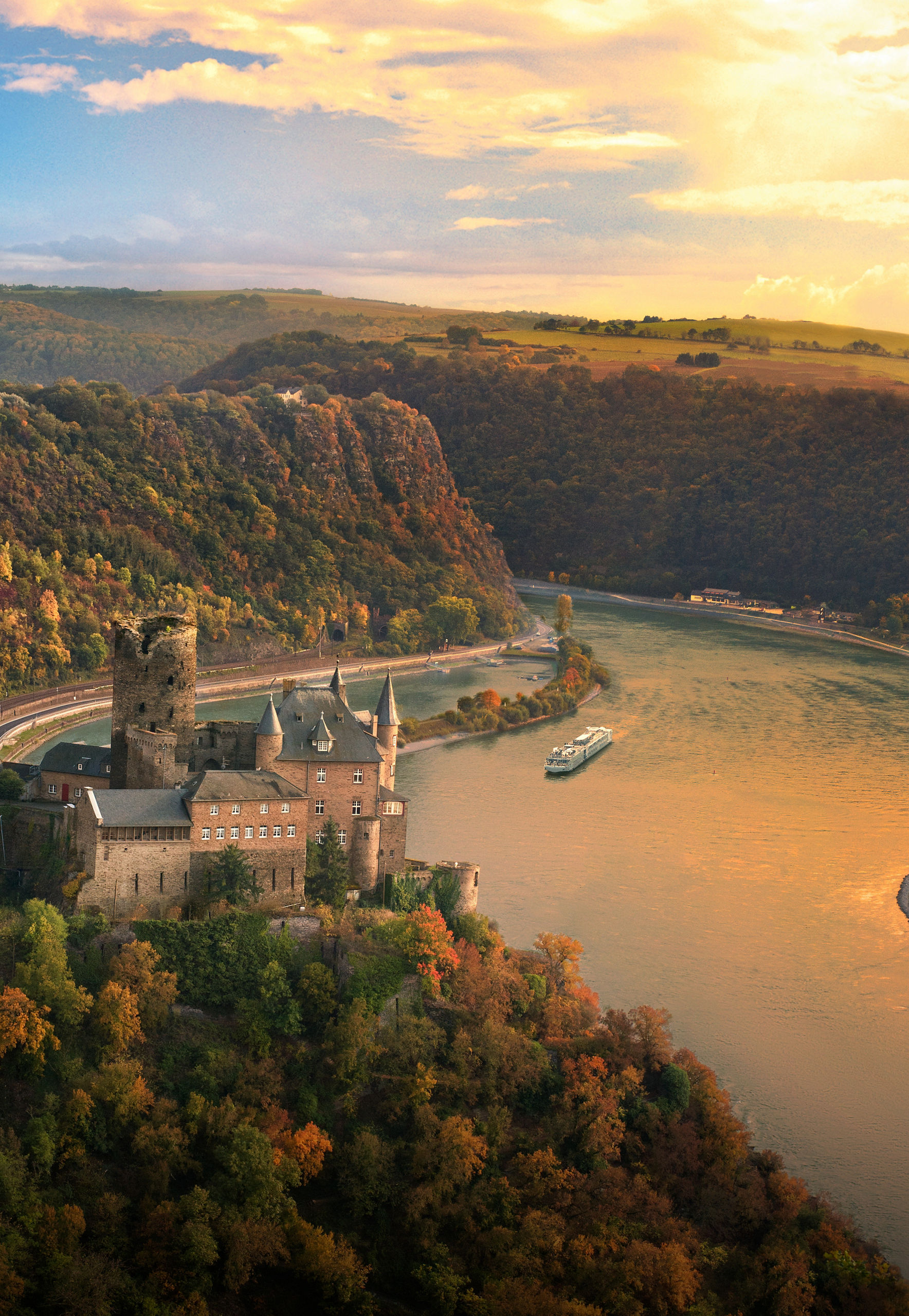 Scenic castle by winding river at sunset