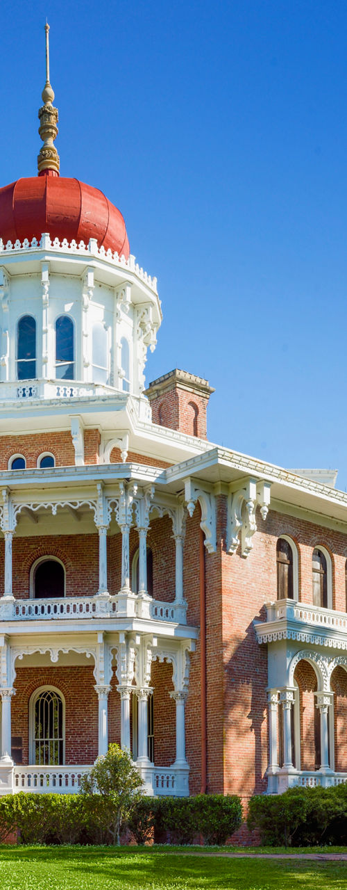 Historic red-domed mansion in lush greenery