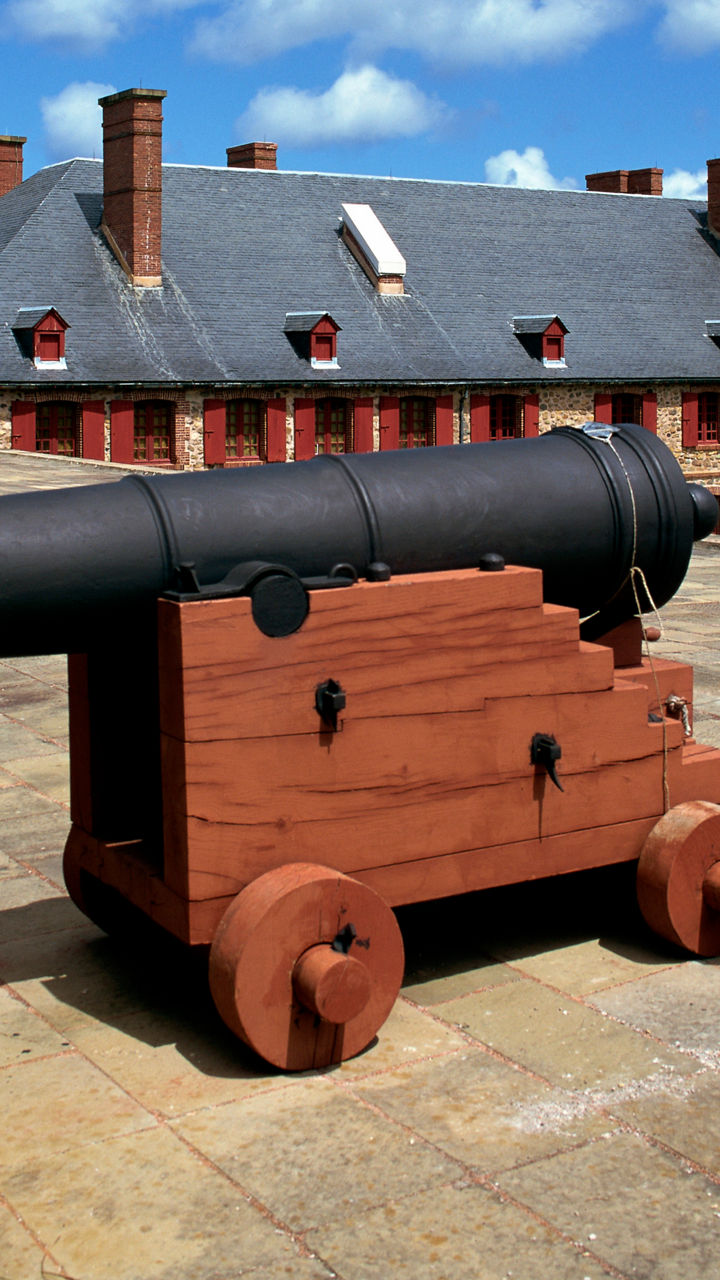 Historic cannon at fortress under blue sky