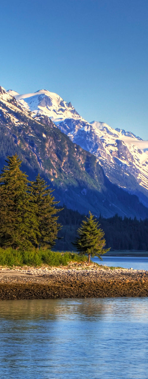 Snow-capped mountains by serene lake