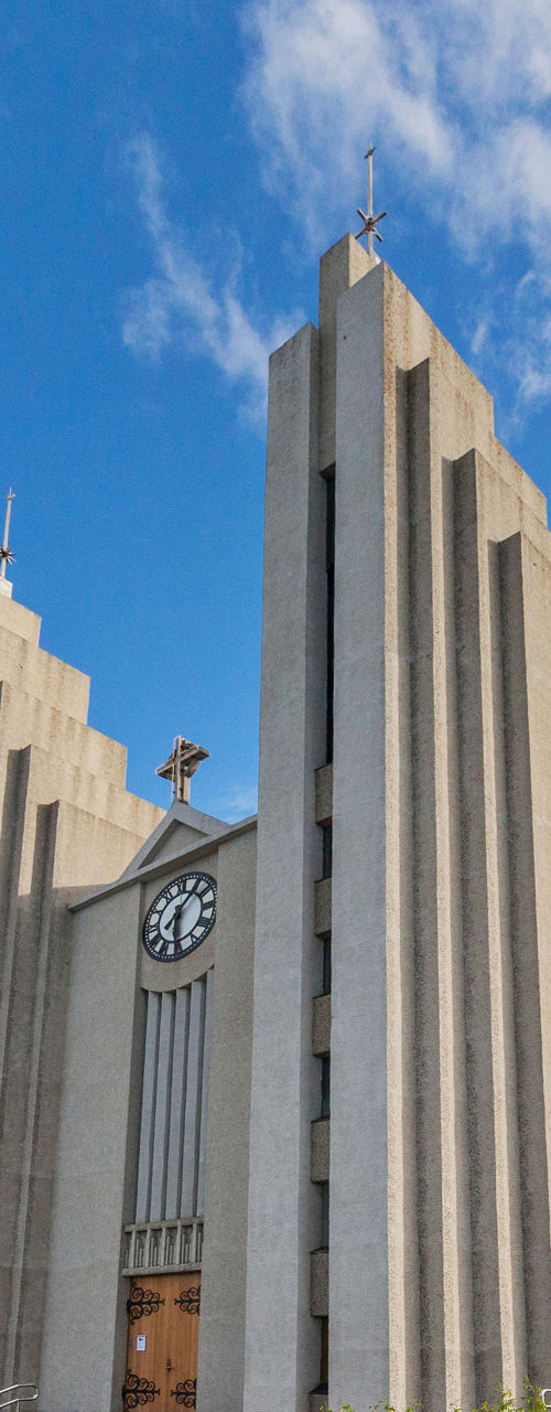 Modern church with clock tower under blue sky