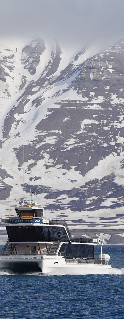 Boat cruising near snowy mountain range