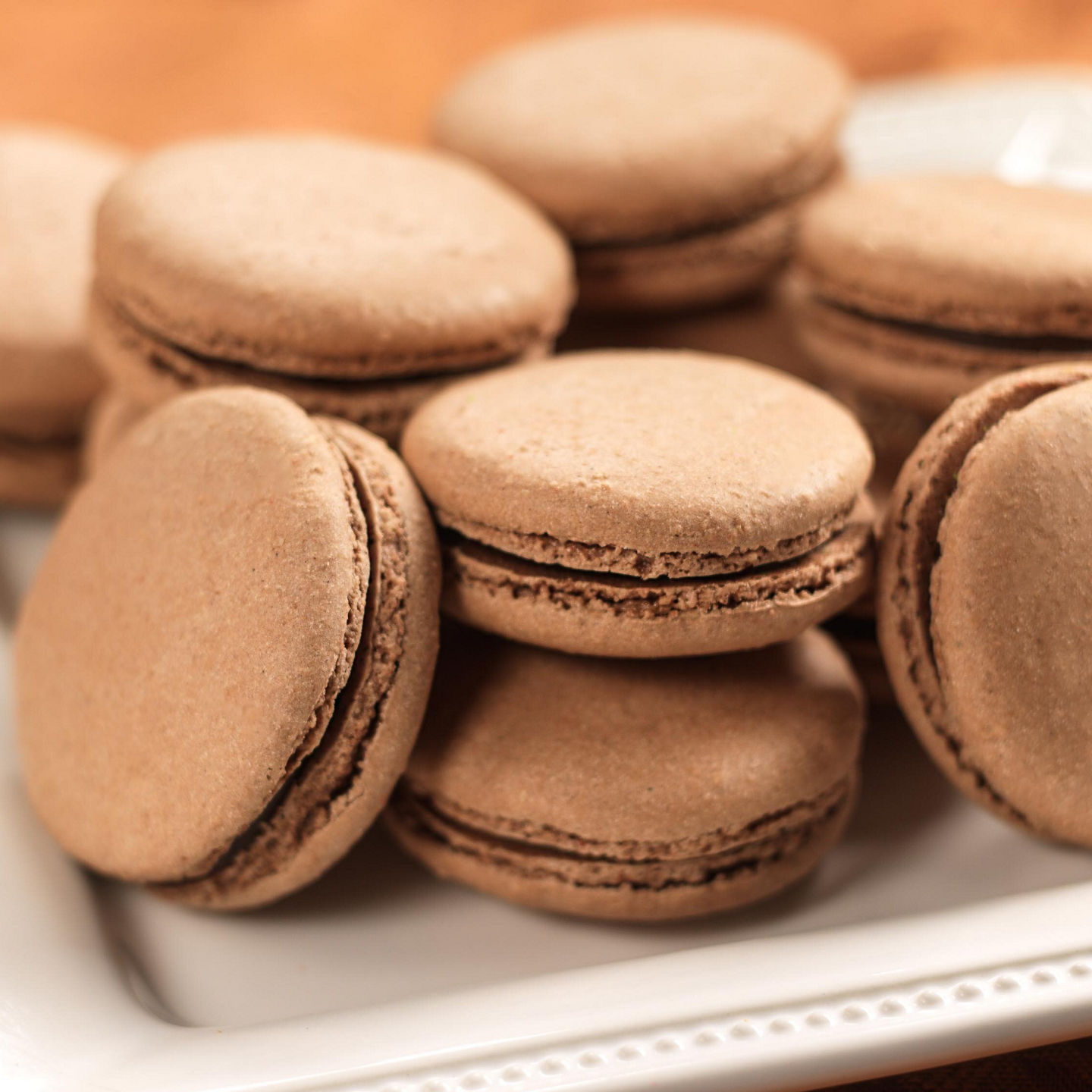 Chocolate macarons on elegant white plate