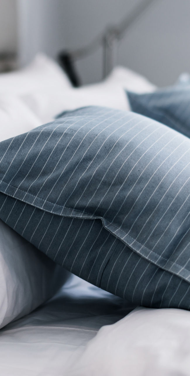 Cozy bed with striped blue pillows