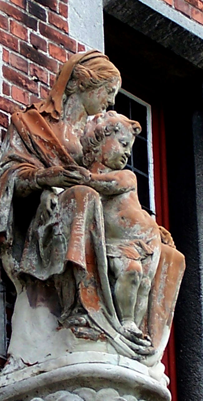 Historic stone sculpture on brick facade