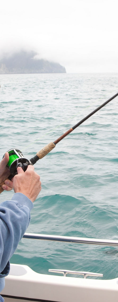 Older man fishing from boat on ocean