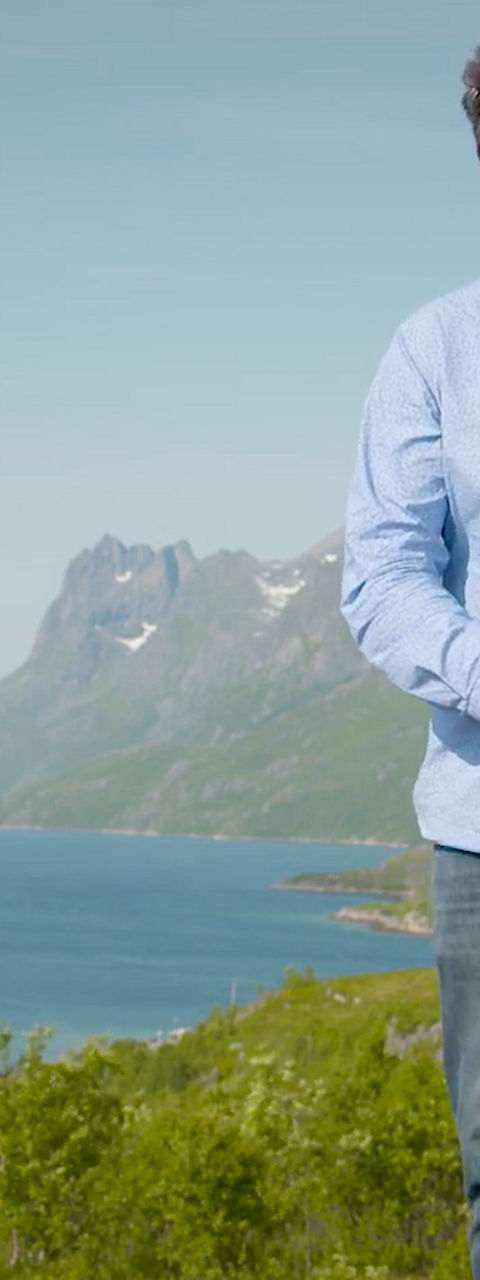 Man holding camera in scenic mountain landscape