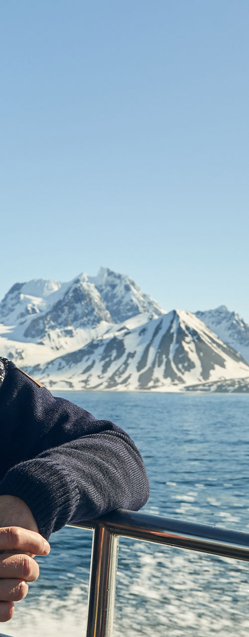Man on boat with snowy mountain view