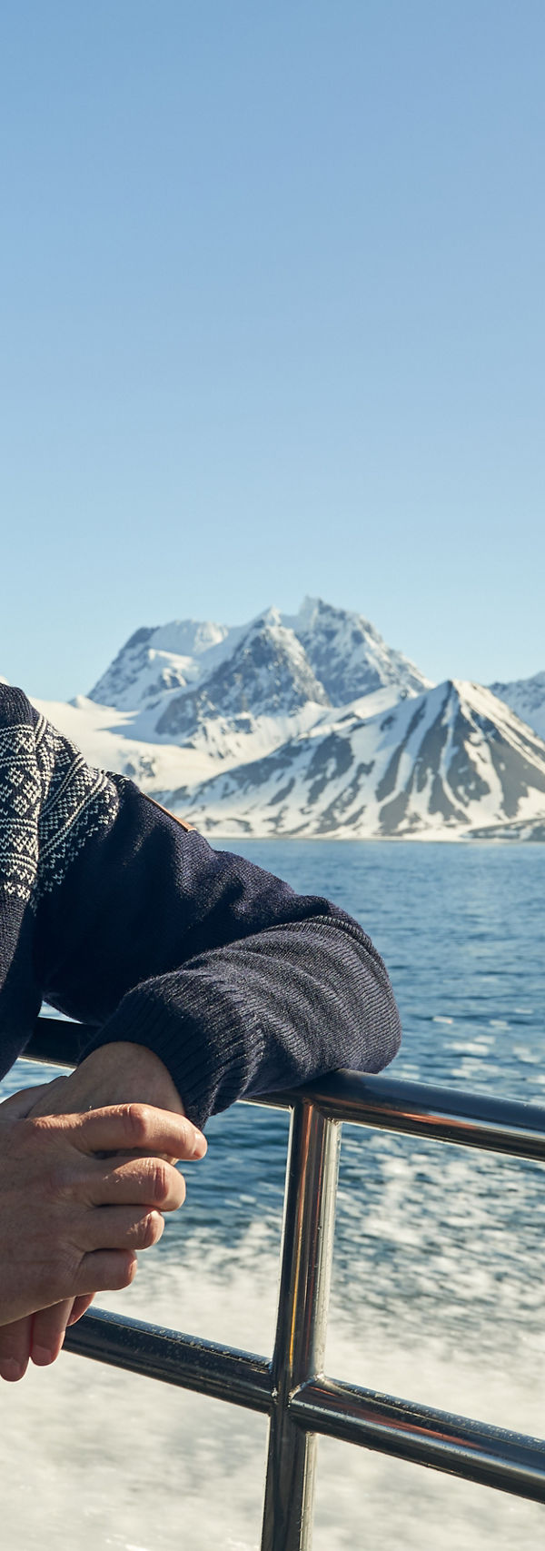 Man on boat with snowy mountain view