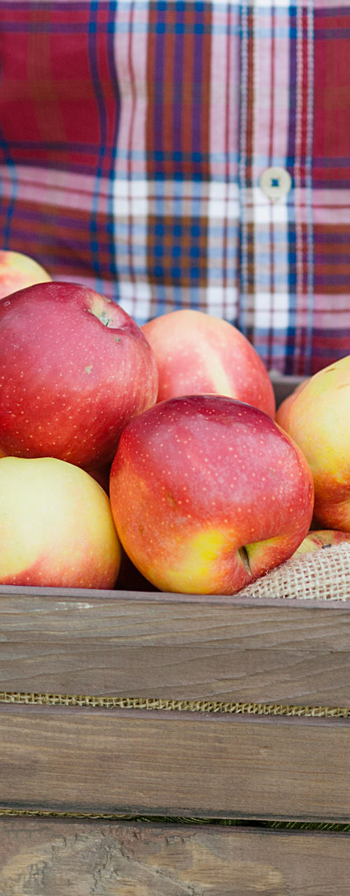 Man holding wooden crate of fresh apples